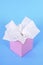Pink kleenex style tissue box, plain blue background, copy space, vertical
