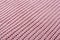 Pink knitted fabric close-up, laid out diagonally, with rough knit