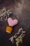 pink knitted heart in a brown knitted pot with small, multi-colored dried flowers on a dark background