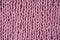 Pink knitted wool fabric close up, macro, background