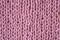 Pink knitted wool fabric close up, macro, background