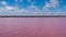 Pink lake and blue sky with shore and horizontal horizon line