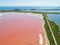 Pink lake Sasyk Sivash. The track and the Black Sea are visible in the background. Selective focus. Taken from the drone