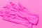 Pink latex gloves to protect against viruses and bacteria. Pink background.
