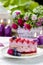 Pink layer cake decorated with fresh fruits