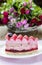 Pink layer cake decorated with fresh fruits