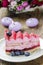 Pink layer cake decorated with fresh fruits
