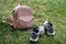 Pink leather female backpack and gray sneakers on a green lawn in the park.