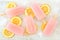 Pink lemonade popsicles with lemon slices on white marble