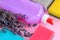 Pink or lilac dishwashing liquid in a transparent plastic bottle, multi colored foam sponges and dry lavender. Kitchen detergent.