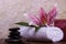 Pink lily flower on white towel and balanced rocks