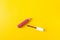Pink lipstick in a golden case for lipstick as a make up item on the yellow mono color background. close up,