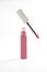 Pink liquid lipstick and applicator brush with open tube. Makeup cosmetic product. Bright background