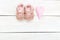 Pink little shoes for baby and pink heart. Copy space