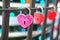 Pink lock in the heart-shape hangs on a lattice