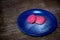 Pink Macaron or Macaroon in blue dish on wooden table.