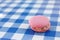 Pink macaron sitting on a blue check pattern