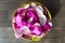 Pink magnolia flower petals in a green ceramic bowl