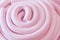 Pink marshmallow closeup, marmalades in shape of twisted spirals. Top view. Sweet pastel background