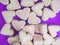 Pink marshmallow in heart shape stacked on violet surface copy space. Sweet candy for love theme on Valentine concept