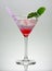A pink martini drink glass with mint twig and straw