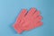 Pink massage gloves for shower on blue background