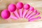Pink measuring spoons in different sizes on wooden table