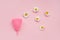 Pink menstrual cup and chamomile flowers isolated on rose background
