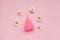 Pink menstrual cup and chamomile flowers isolated on rose background,  menstruation cycle, women gynecological health and intimate