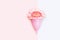 Pink menstrual cup and a flower on on pink and white background