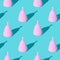 Pink menstrual cup on a green background. Set. Seamless texture pattern. Long harsh shadow from the summer sunshine