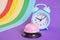 Pink metal service bell and Blue alarm clock on colorul rainbow background