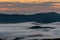 Pink Morning Light in Sky with Mountain Island Through Clouds