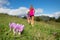 Pink mountain flower with girls running in the meadow