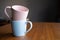 Pink mug on a blue mug.