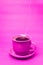 Pink mug with steaming hot coffee. Soft smoke. Pink background.