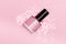 Pink nail polish bottle on pink background. Pink nail polish bottle decorated with small glitter pink stars