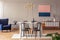 Pink and navy blue abstract painting on a gray wall with molding in an elegant dining and living room