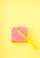 Pink neon color smeared on a piece of bread on a yellow background. The  yellow knife is on the bread. Creative food concept,