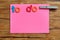 A pink note with the words to do and a peg attached with the word saturday on it