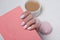 Pink notepad in a female hand. Gentle manicure. Close-up