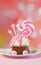 Pink novelty cupcake decorated with candy and large lollipop.