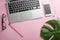 Pink office desk with an empty laptop, computer keyboard and other stationery. Top view with copy space, flat lying.