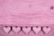 Pink old wooden background with five hearts for a greeting card.