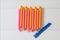 Pink and orange hair curlers on lght wooden background