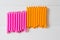 Pink and orange hair curlers on lght wooden background