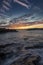 Pink and orange sunset over coastal rocks and sea