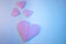 Pink origami hearts on a blue background