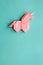 Pink origami unicorn on cyan blue background