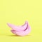 Pink painted banana on pastel yellow background
